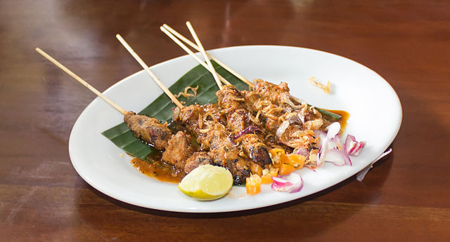 Sate ayam with shallots and lime wedges