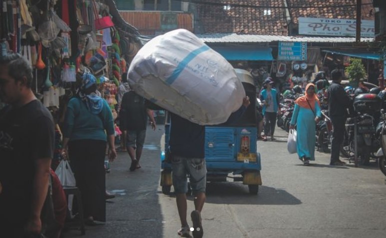 A man carries the order at the alley of Pasar Jatinegara