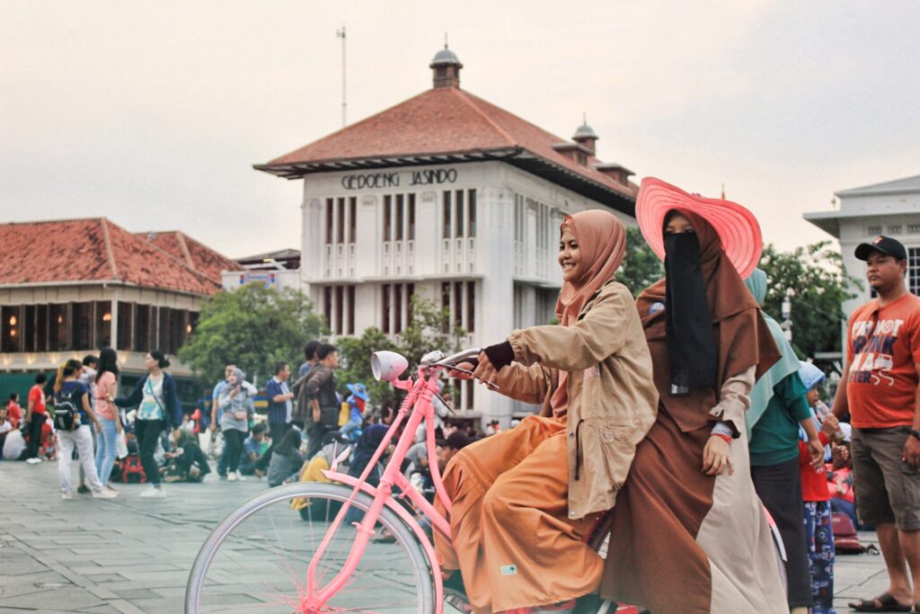 Two women rode bicycle together at Kota Tua