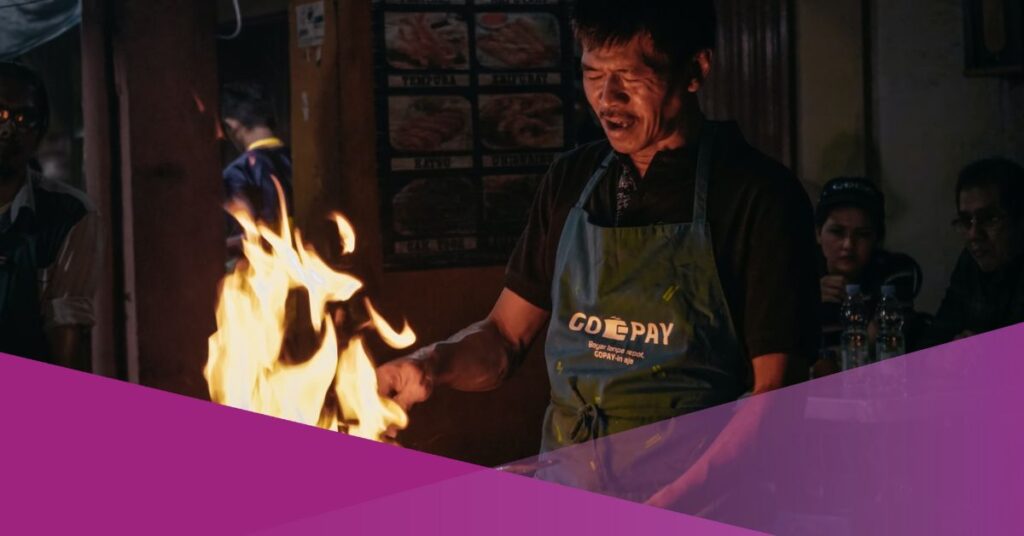 A street cook processes his dish