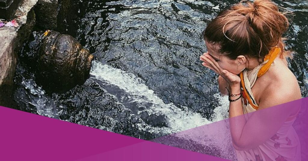 A woman practices water healing in Tirta Empul Temple